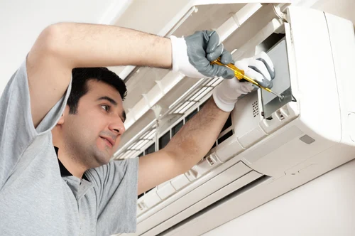 Technician repairing split AC unit